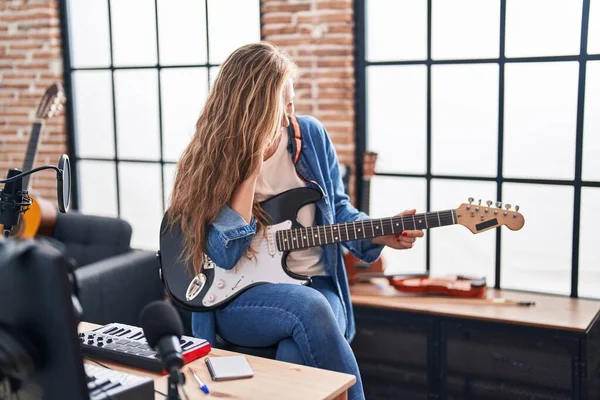 若いですブロンド女性ミュージシャン遊びます電気ギタートーク上のスマートフォンで音楽スタジオ — ストック写真
