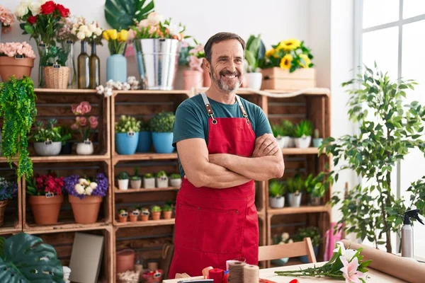 Middle age man florist smiling confident standing with arms crossed gesture at florist