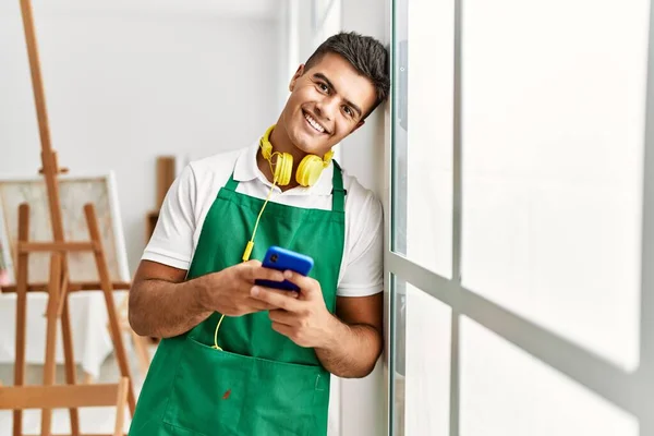 Young Hispanic Man Using Smartphone Leaning Window Art Studio — Φωτογραφία Αρχείου