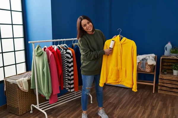 Young Beautiful Hispanic Woman Smiling Confident Cleaning Sweatshirt Using Pet — Stockfoto