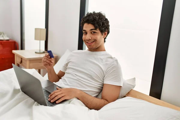 Fiatal Spanyol Férfi Vásárol Laptoppal Hitelkártyával Ágyon Hálószobában — Stock Fotó