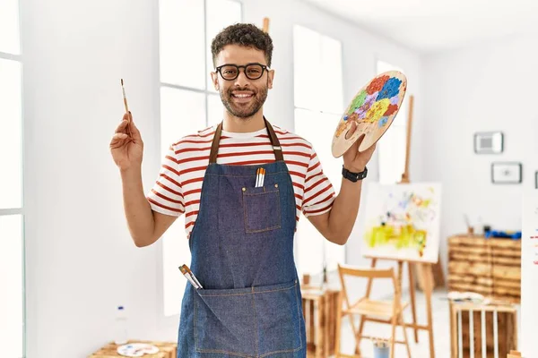 Joven Artista Árabe Sonriendo Feliz Sosteniendo Pincel Paleta Estudio Arte — Foto de Stock