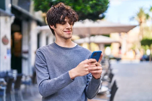 Młody Hiszpan Uśmiecha Się Pewnie Używając Smartfona Ulicy — Zdjęcie stockowe