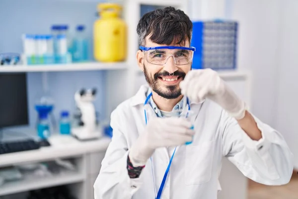 若いヒスパニック系の男研究室でガラス上の液体を混合科学者 — ストック写真