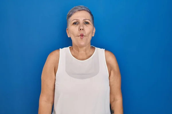 Orta Yaşlı Beyaz Bir Kadın Mavi Arka Planda Durup Dudaklarıyla — Stok fotoğraf