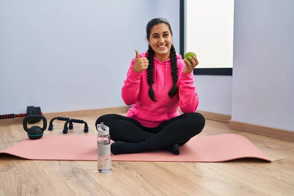 Young Hispanic Woman Sitting Yoga Mat Eating Apple Smiling Happy — Stockfoto