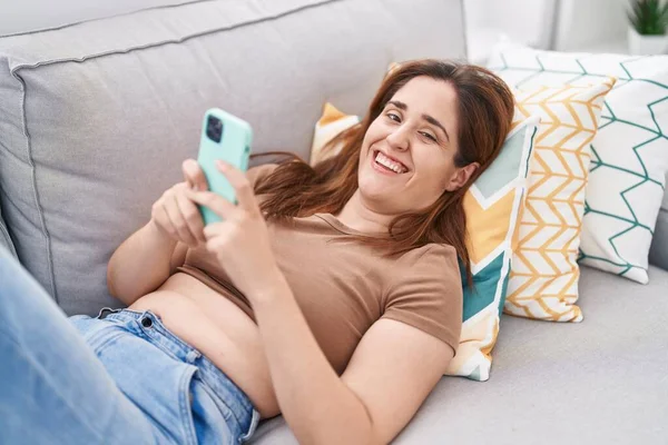 Giovane Donna Utilizzando Smartphone Sdraiato Sul Divano Casa — Foto Stock