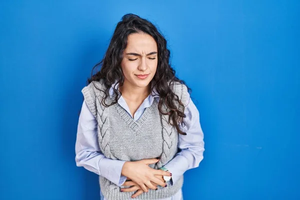 Mujer Morena Joven Pie Sobre Fondo Azul Con Mano Estómago —  Fotos de Stock