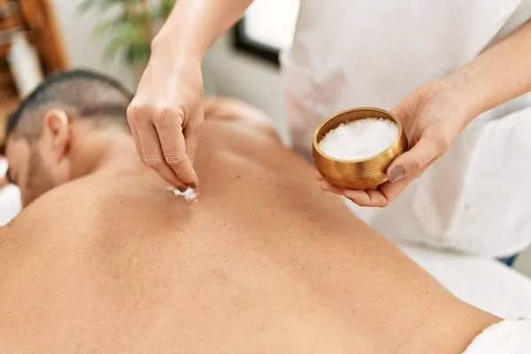 Young Hispanic Man Having Back Massage Using Salt Beauty Center — Zdjęcie stockowe