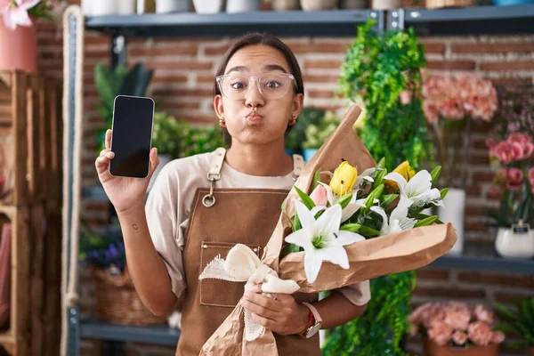 Mladá Hispánka Pracující Květinářství Ukazující Obrazovku Smartphonu Legračním Obličejem Tvářích — Stock fotografie