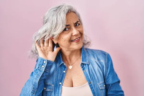 Pembe Arka Planda Duran Gri Saçlı Orta Yaşlı Bir Kadın — Stok fotoğraf