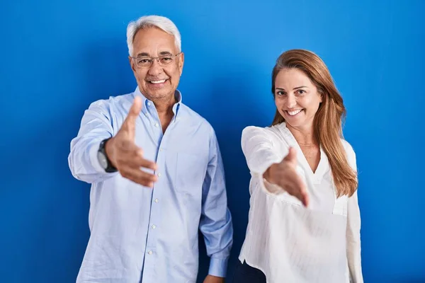 Medelåldern Latinamerikanska Par Står Över Blå Bakgrund Leende Vänlig Erbjuder — Stockfoto