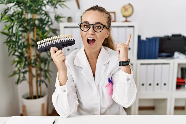 Young Caucasian Woman Holding Teeth Whitening Palette Pointing Finger Successful — Stock Photo, Image