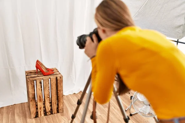 年轻的高加索女摄影师在摄影棚为高跟鞋拍照 — 图库照片