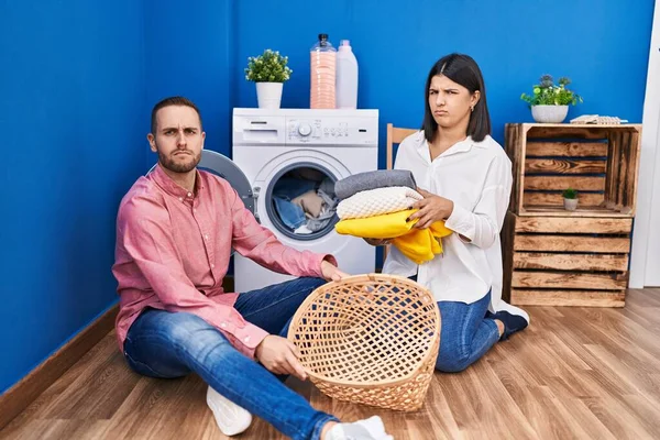 家で洗濯をする若いカップルは懐疑的で緊張し 問題のために動揺を眉をひそめています 否定的な人 — ストック写真