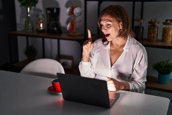 Latynoska Kobieta Średnim Wieku Używająca Laptopa Domu Nocy Wskazując Palcem — Zdjęcie stockowe