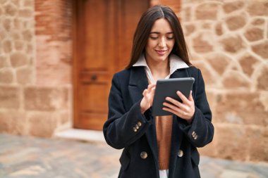 Sokakta dokunmatik ped kullanan, kendine güvenen, güzel İspanyol bir kadın.