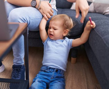 Anne ve oğlu evde yerde ağlıyor.