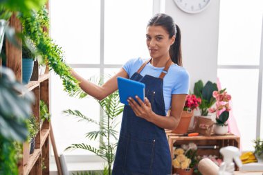 Çiçekçiye dokunarak gülen güzel İspanyol kadın çiçekçi.