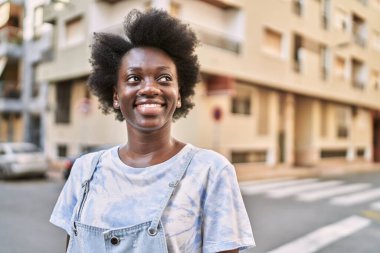 Young african woman smiling confident at street