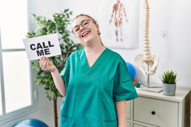 Ağrı kesici kliniğinde çalışan genç kızıl saçlı kadın bana Banner de. Olumlu ve mutlu görün. Kendine güvenen bir gülümsemeyle dişlerini göster. 