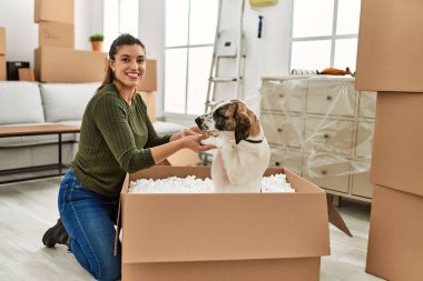Evde köpekle oynarken kendine güvenen genç bir kadın.