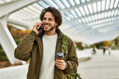 Yakışıklı İspanyol adam, şehirde telefonla konuşuyor.