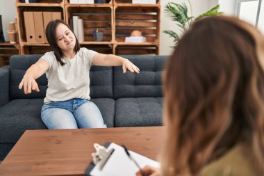 Down sendromlu İspanyol kız terapi yapıyor kameraya sarılıp gülümsüyor. Mutluluğu kucaklayan neşeli bir ifade.. 