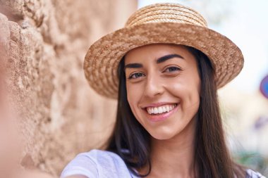 Young hispanic woman tourist smiling confident making selfie by the camera at street