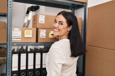 Genç, güzel, İspanyol bir kadın. İş adamı. Ofiste bir pakete yazıyor.