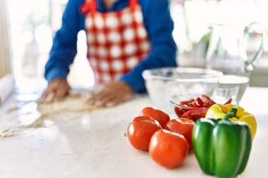 Son sınıf öğrencisi mutfakta elleriyle pizza hamuru pişiriyor.