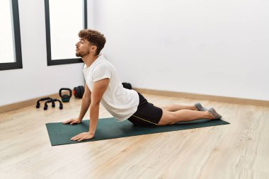 Young arab man stretching at sport center