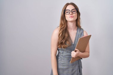 Caucasian woman wearing glasses and business clothes looking at the camera blowing a kiss on air being lovely and sexy. love expression. 