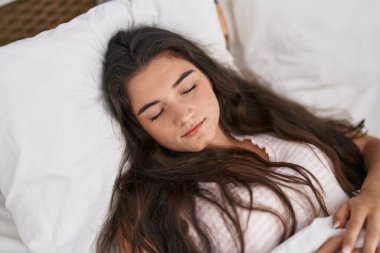 Young hispanic woman lying on bed sleeping at bedroom