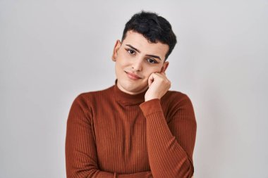 Non binary person wearing make up standing over isolated background thinking looking tired and bored with depression problems with crossed arms. 