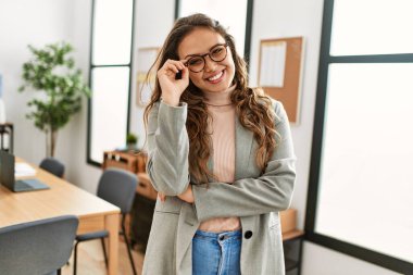 Genç, güzel, İspanyol bir iş adamı. Kendine güler yüzlü. Ofiste kollarını kavuşturmuş duruyor.