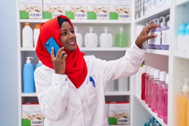 Eczanede akıllı telefondan konuşan güzel bir kadın eczacı.