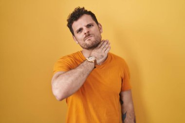 Sarı arka planda dikilen genç İspanyol adam bıçakla boğazı kesiyor, saldırganlığı şiddetle tehdit ediyor. 