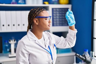African american woman scientist looking sample at laboratory