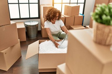 Orta yaşlı İspanyol kadın gülümsüyor kendine güvenen yeni evine taşınıyor