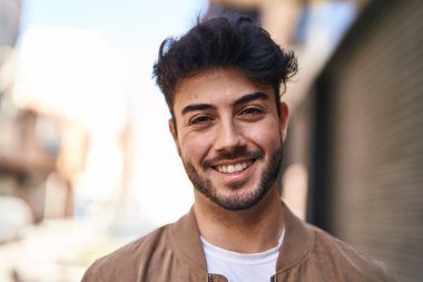 Sokakta kendinden emin gülümseyen İspanyol genç adam.