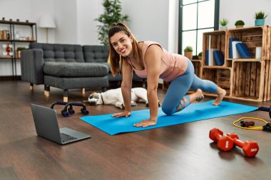 Evde karın kası egzersizi dersi alan kendine güvenen genç bir kadın.