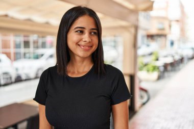 Sokakta kendine güvenen genç Latin kadın gülümsüyor