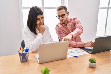 Kadın ve erkek işçiler ofiste çalışıyor.