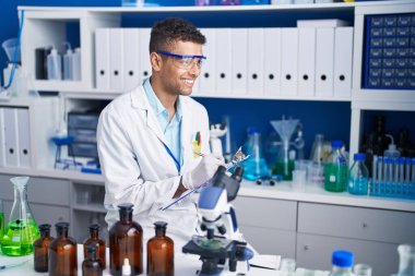 Afrikalı Amerikalı bilim adamı, laboratuardaki belgelere yazı yazıyor.