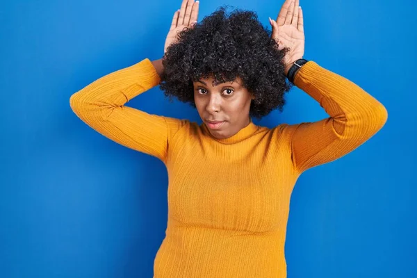Black Woman Curly Hair Standing Blue Background Doing Bunny Ears — Zdjęcie stockowe