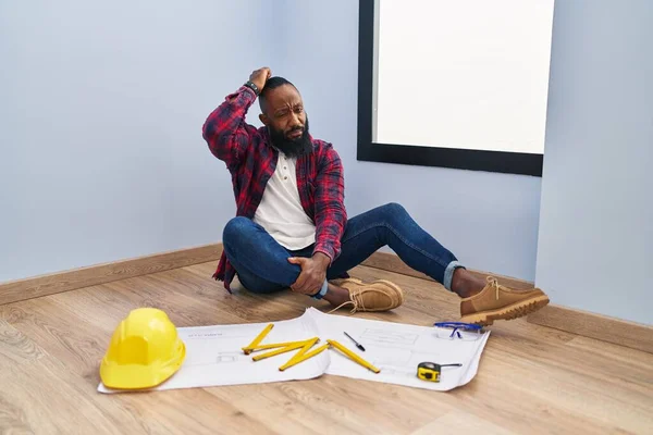 Afroameričan Který Sedí Podlaze Novém Domově Dívá Plány Zmatený Přemýšlí — Stock fotografie