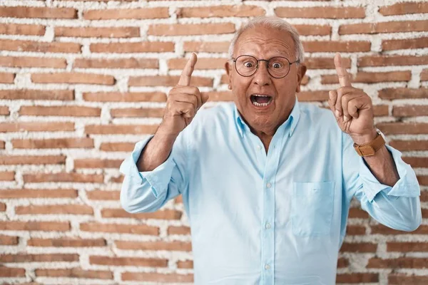 Tuğla Duvarın Üzerinde Duran Yaşlı Adam Şaşırmış Şaşırmış Parmaklarıyla Işaret — Stok fotoğraf
