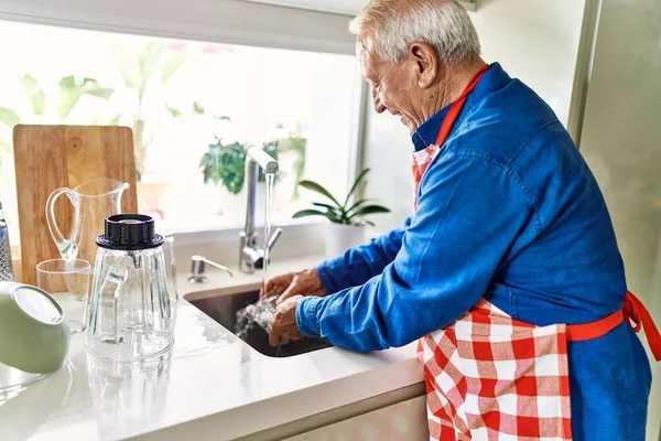 老人带着自信的笑容在厨房洗杯子 — 图库照片