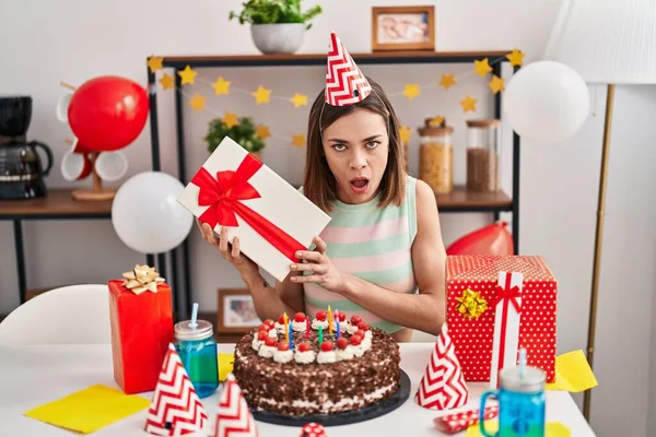 西班牙女人带着蛋糕庆祝生日 脸上带着震惊的表情 脸上带着怀疑和讽刺的表情 张大了嘴 惊讶极了 — 图库照片